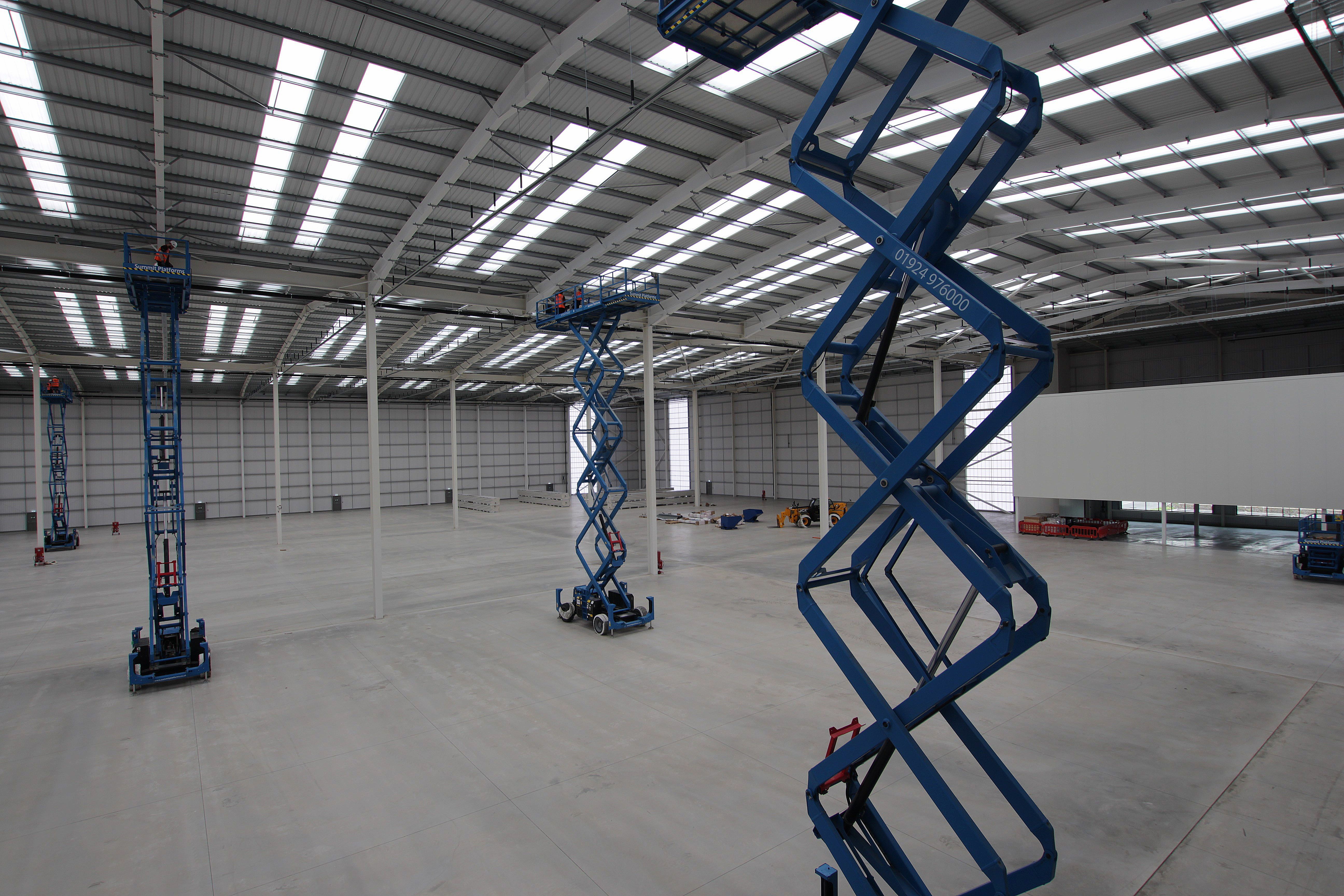 Scissor lifts in large warehouse during panel upgrade
